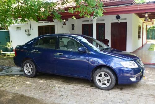 a blue car parked in front of a house at Villa Thotiya in Aluthgama