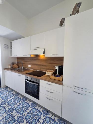 a kitchen with white cabinets and a stove top oven at Camera con Vista in Termoli