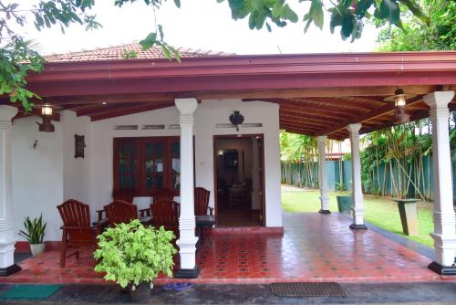 a house with a red roof and a patio at Villa Thotiya in Aluthgama