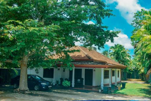 a small house with a tree in front of it at Villa Thotiya in Aluthgama