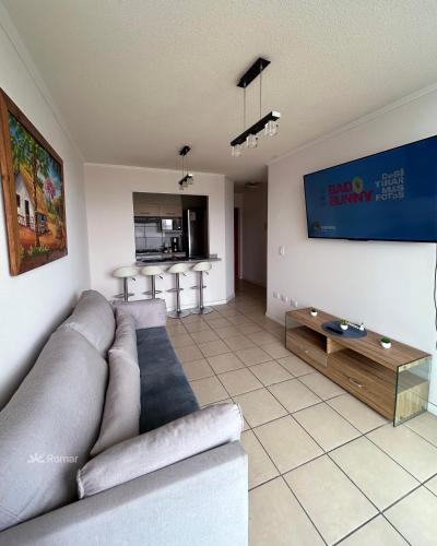 a living room with a couch and a tv at Romar Departamentos Vista al Mar Costanera in Coquimbo