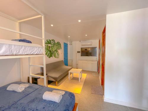 a bedroom with a bunk bed and a living room at The Blue Doors- Siargao in General Luna