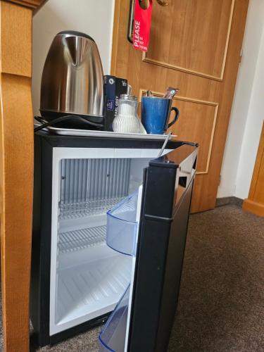 an empty refrigerator with its door open in a room at Brezina Pension in Prague