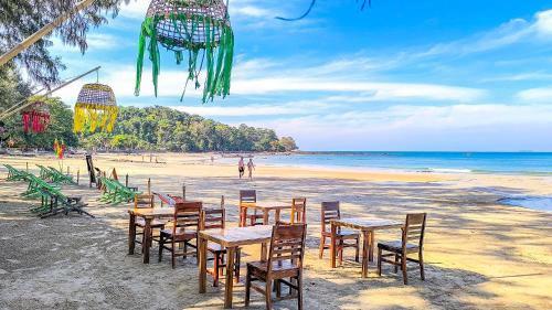 a group of tables and chairs on a beach at Le Panpurie Koh Lanta Resort in Ko Lanta Yai