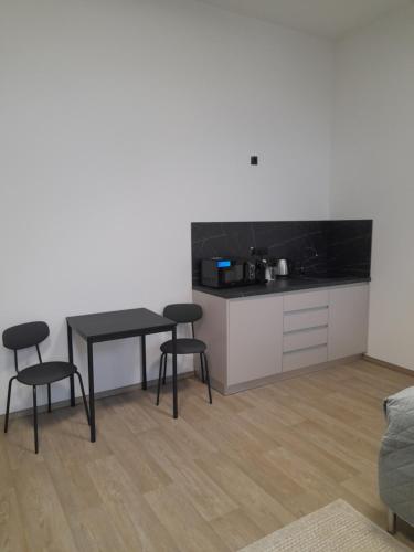 a kitchen with a table and two stools in a room at Penzion Klas in Měřín