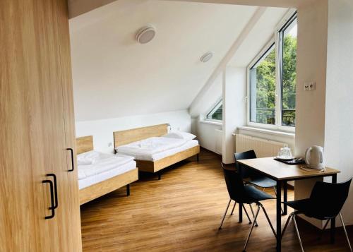 a room with two beds and a table and chairs at Sanatorium Rosomak in Ustroń