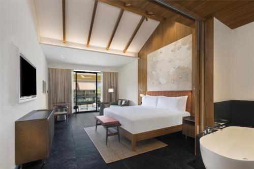 a hotel room with a bed and a bathroom at Hilton Hyderabad Genome Valley Resort & Spa in Hyderabad