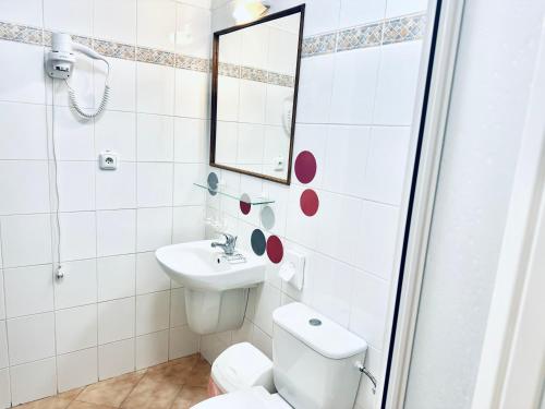 a bathroom with a toilet and a sink and a mirror at Penzion Chalupa U Městské brány in Vyškov