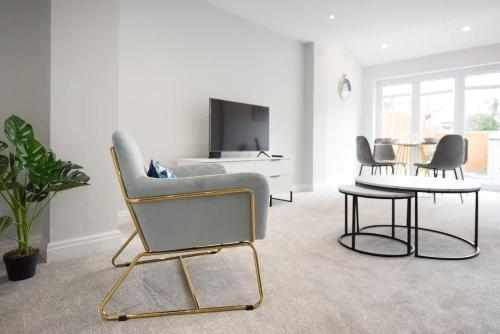 ein Wohnzimmer mit einem Stuhl und einem Tisch in der Unterkunft Parking Space, Doors onto Garden-Pet Friendly in Romford