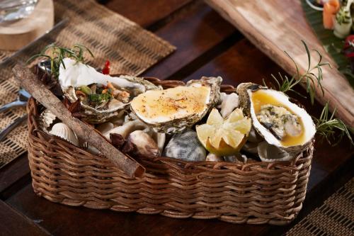 a basket filled with oysters and mushrooms on a table at L'Alya Ninh Van Bay in Ninh Van Bay