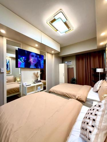 une chambre avec deux lits et une télévision à écran plat dans l'établissement SWEET MEMORIES CONDOTEL at THE SYMPHONY TOWERS QC, à Manille