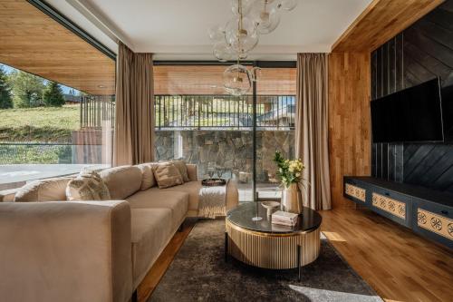 a living room with a couch and a tv at Landscape Villas - LoftAffair Spa Collection in Kościelisko