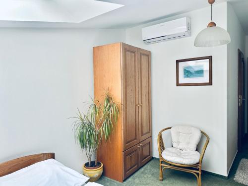 a bedroom with a chair and a cabinet at Penzion Chalupa U Městské brány in Vyškov