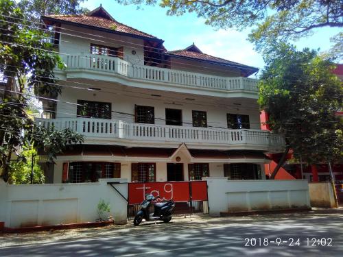 un edificio con una moto parcheggiata di fronte di TagUndNacht Homestay a Cochin
