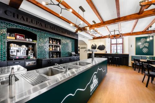 a restaurant with a counter with a sink and a bar at Penzion Chalupa U Městské brány in Vyškov