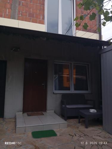 Un patio negro con un banco y una ventana. en Marina, en Sremčica