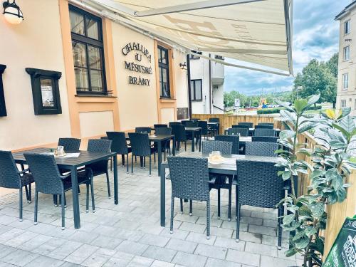 a restaurant with tables and chairs on a patio at Penzion Chalupa U Městské brány in Vyškov