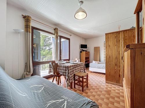 a bedroom with a bed and a table in a room at Le Sciurus - Studio avec terrasse - Parking in Font Romeu Odeillo Via