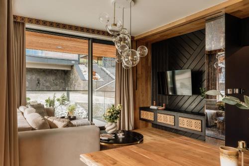 a living room with a couch and a large window at Landscape Villas - LoftAffair Spa Collection in Kościelisko
