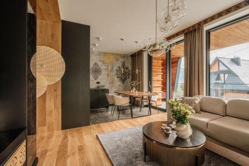 a living room with a couch and a table at Landscape Villas - LoftAffair Spa Collection in Kościelisko