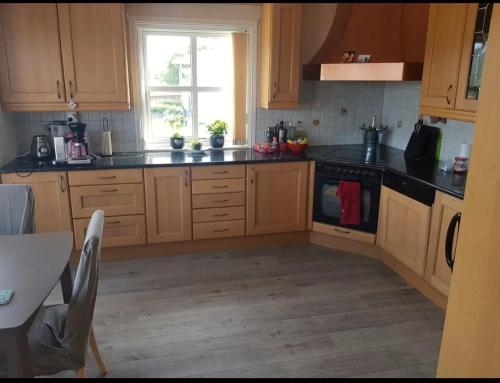 a kitchen with wooden cabinets and a window at Exclusive villa by the sea, close to Saltstraumen in Bodø