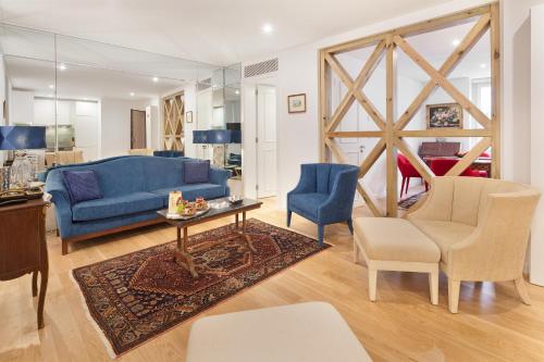 a living room with a blue couch and chairs at Lisbon Rentals Chiado in Lisbon