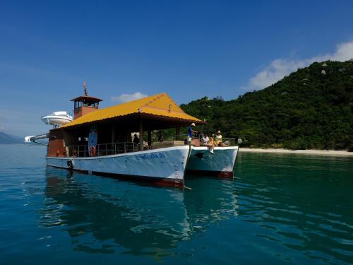 a boat with a yellow roof on the water at L'Alya Ninh Van Bay in Ninh Van Bay