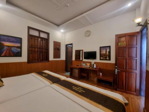 a bedroom with a bed and a desk and a tv at Window 2 Hotel in Kon Tum