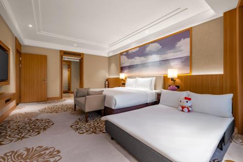 a hotel room with two beds and a couch at Xiamen C&D Hotel-Free Welcome Snacks-Oasis Garden in Xiamen