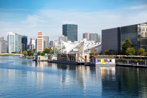 a view of a city from a river with buildings at PETALS TOKYO - Floating Hotel in Tokyo
