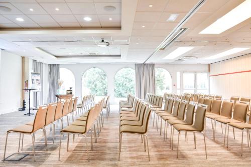 a row of chairs in a room with windows at Hotel Mercure Parc du Coudray - Barbizon in Le Coudray-Montceaux