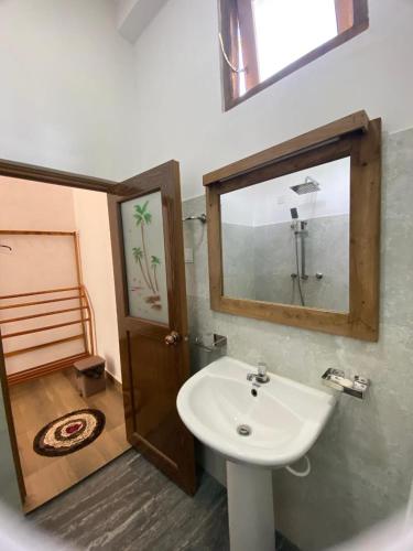 a bathroom with a sink and a mirror at Grandmila Resort in Anuradhapura
