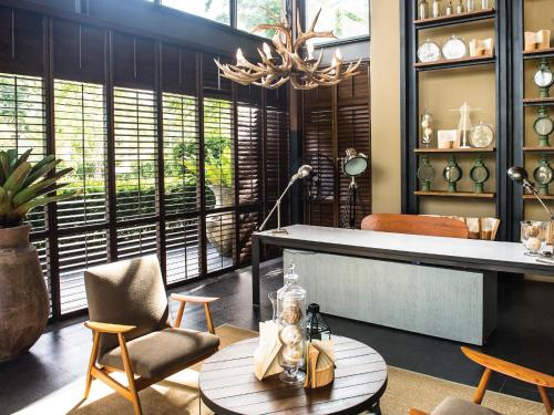 a living room with a table and chairs at Atta Lakeside Resort Suite - SHA Plus Certified in Mu Si