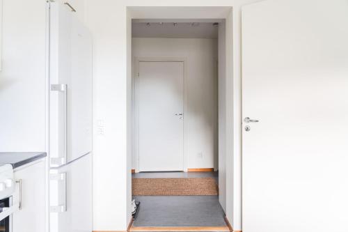a hallway with a door leading into a room at Guestly Homes - Homely 1BR Apartment in Luleå