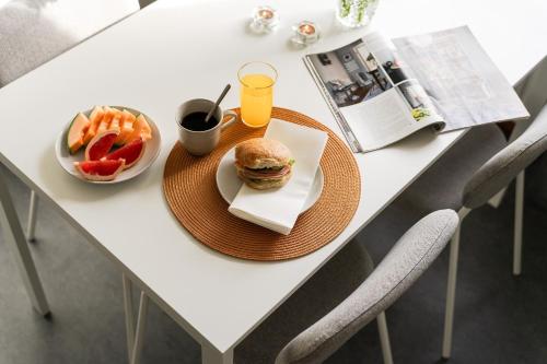 a table with a sandwich and french fries and a drink at Guestly Homes - Homely 1BR Apartment in Luleå