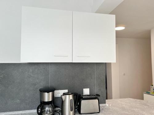 ゲーラにあるBüchner 52-1の白いキャビネットとカウンタートップを備えたキッチン