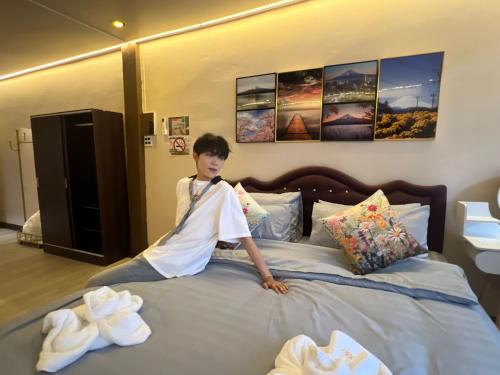 a young boy sitting on top of a bed at Moochi Home Ratchada in Bangkok