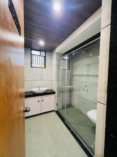 a bathroom with a shower and a sink and a toilet at Hotel Mauli Lodging in Ahmadnagar