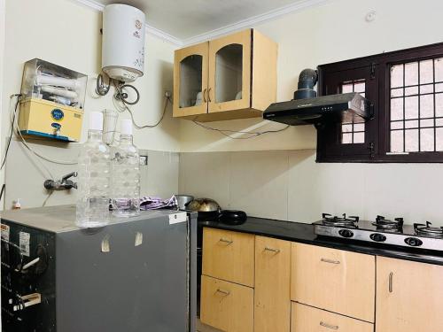 a kitchen with a stainless steel refrigerator and wooden cabinets at Kamlam Homes- Bhowali Villa in Bhowāli