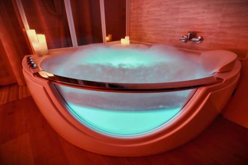 a bath tub in a room with a blue light at Nuit romantique détente et SPA Blagnac Toulouse in Blagnac