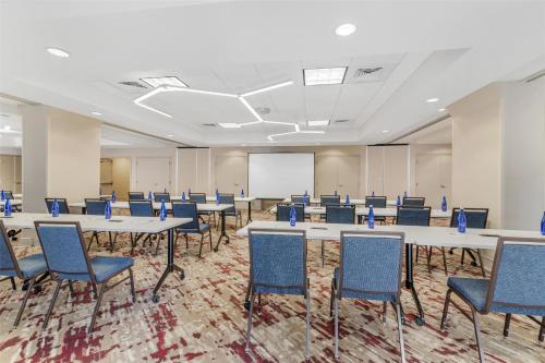a conference room with tables and chairs and a whiteboard at Hilton Garden Inn Albany-SUNY Area in Albany