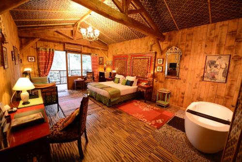 a bedroom with a bed and a tub in a room at Cit'Hotel Le Relais du Boisniard in Chambretaud
