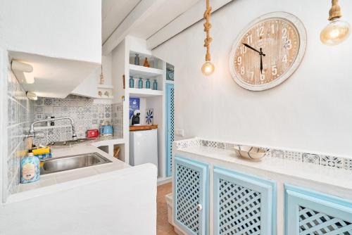 una cucina con un lavandino e un orologio a parete di La Casa Bonita a Frigiliana