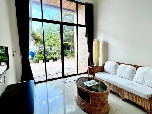 a living room with a couch and a large window at Baancivilize Resort in Khanom