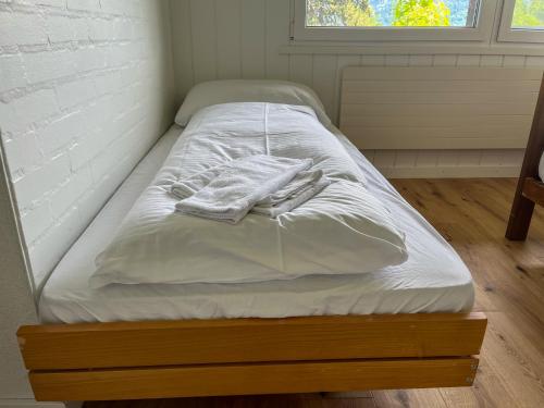 a bed with white sheets and towels on it at Seepanorama Güetital in Faulensee