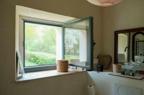 a bathroom with a large window in a bathroom at Maison Nomade Perche - MaisonNomadeChic in Cour-Maugis-sur-Huisne