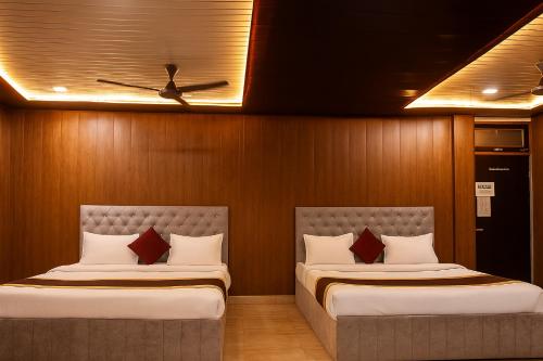 two beds in a room with wooden walls at Comfort Stay - Saheed Path Ahimamau, Near Lulu Mall in Lucknow