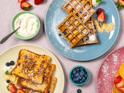 einen Tisch mit zwei Waffeln und Obst in der Unterkunft Adagio Premium The Palm in Dubai