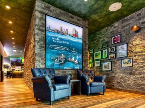 a waiting room with two chairs and a large screen at ibis Styles Hamburg Barmbek in Hamburg