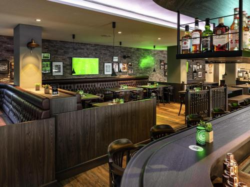a restaurant with a bar and a tv on the wall at ibis Styles Hamburg Barmbek in Hamburg